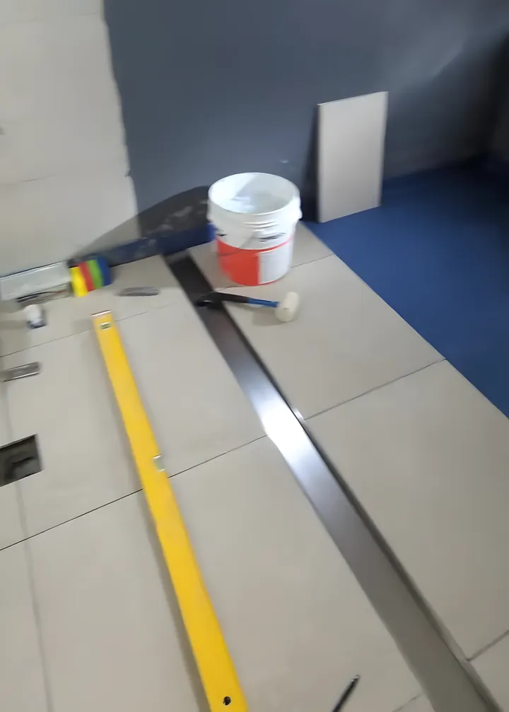 Garden Suburb bathroom: membrane on the floor with the first large floor tiles going down